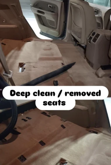 Vehicle interior deep clean with seats removed showing full carpet and floor restoration